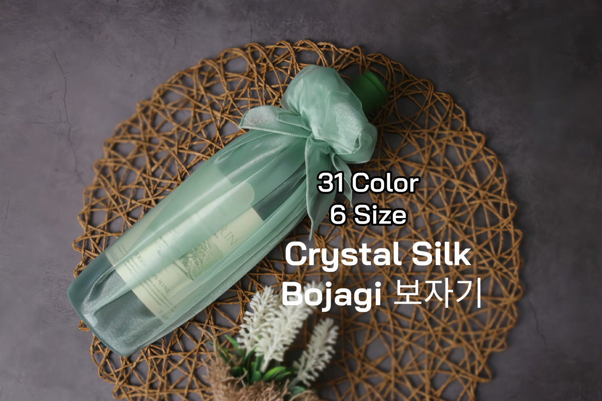 a bottle of wine wrapped with mint color see through fabric wrap(Bojagi).