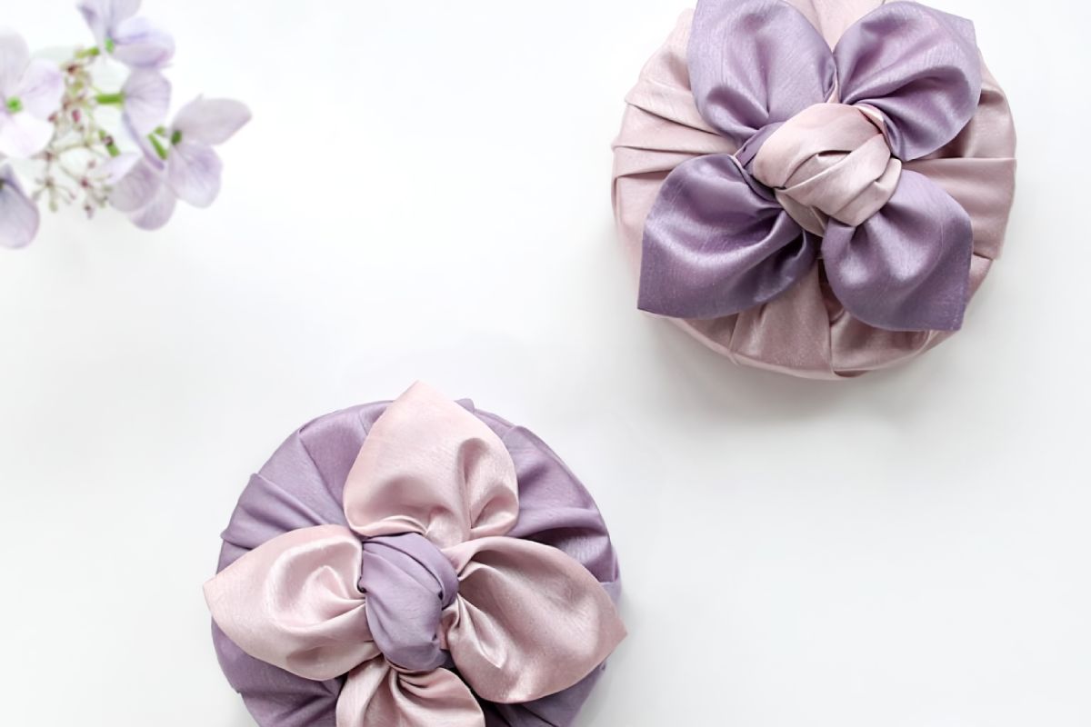two round boxes wrapped with light purple and pink color Bojagi.