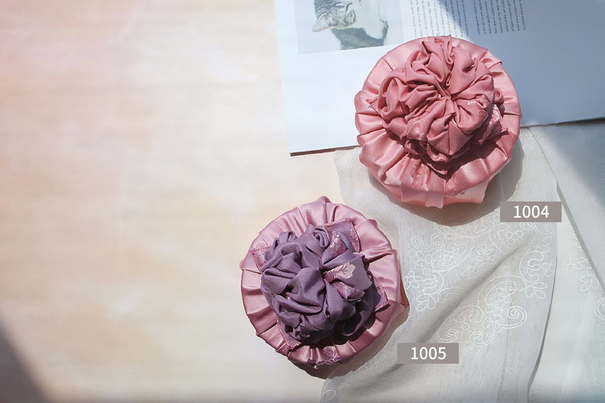two round boxes wrapped with light purple and pink color Bojagi.